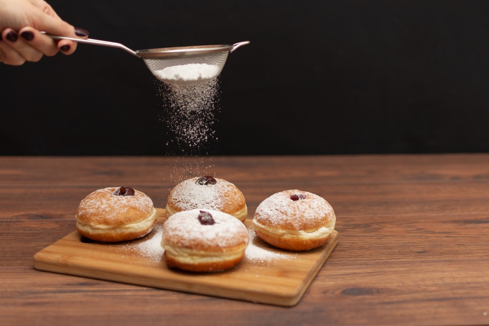 Hanukkah Sufganiyot. Traditional Jewish Donuts For Hanukkah With Red Jam And Sugar Powder.